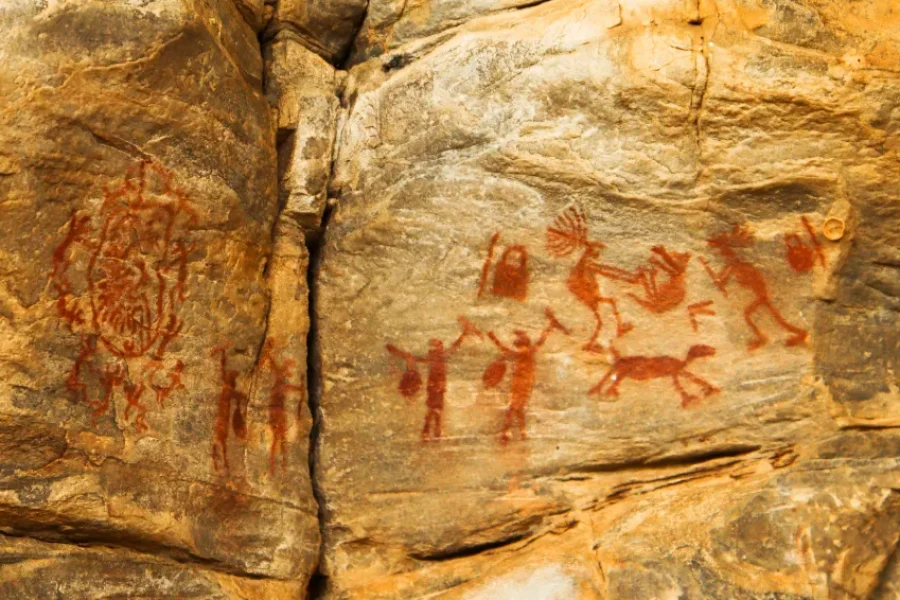 Arte rupestre em ocre vermelho no Geoparque Seridó, Brasil, com figuras humanas e animais pintadas em rocha arenítica