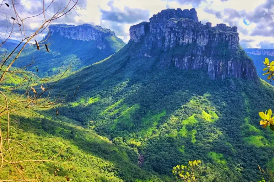 Vue du majestueux Morro do Castelo avec sa forme caractéristique en mesa s'élevant au-dessus de la luxuriante forêt verte de la Chapada Diamantina, sous un ciel partiellement nuageux, en Bahia, Brésil.