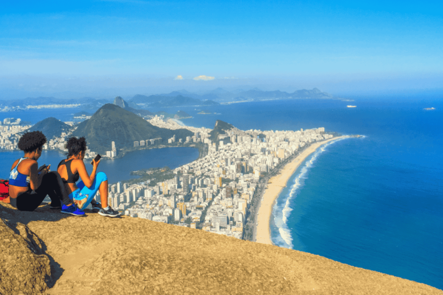 Panoramic view of Rio de Janeiro from the Dois Irmãos viewpoint, featuring the beaches of Ipanema and Leblon, the Atlantic Ocean, and the cityscape seen from above.