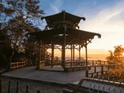 Il padiglione in stile orientale della Vista Chinesa al tramonto, con la struttura in legno sagomata contro un cielo arancione e la Baia di Guanabara sullo sfondo, nella Foresta di Tijuca, Rio de Janeiro, Brasile.