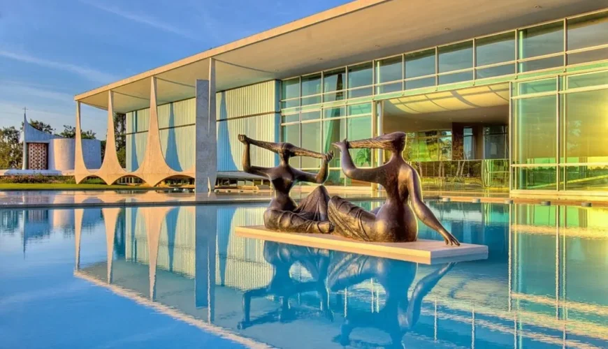 Palácio da Alvorada em Brasília, com escultura em bronze no espelho de água e as colunas curvas da fachada